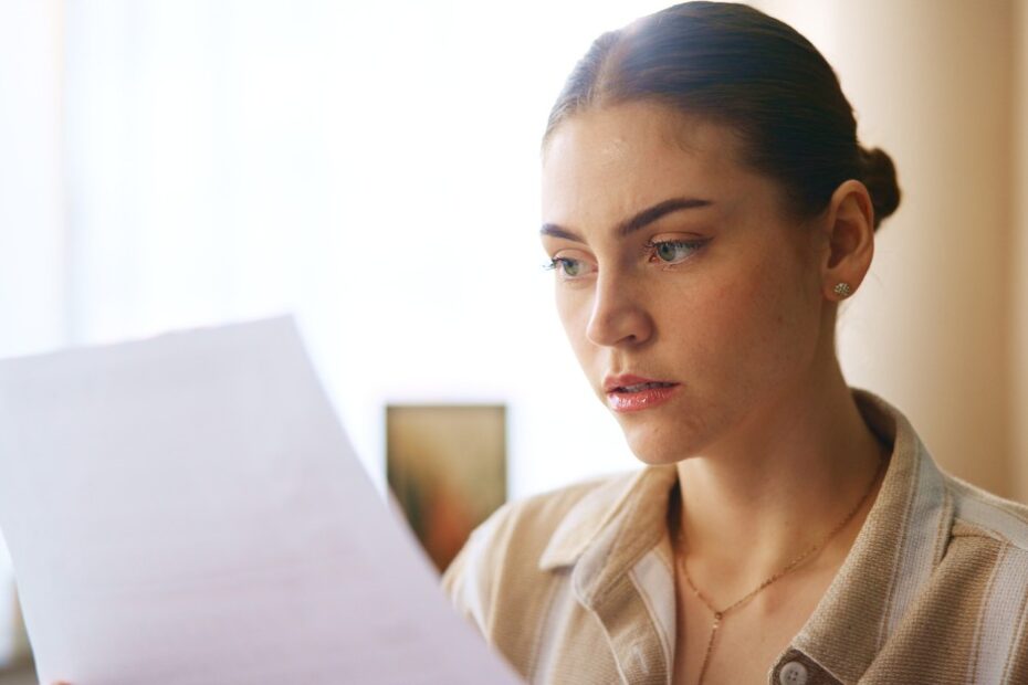 Woman holding an employment contract, reviewing 5 critical clauses before signing