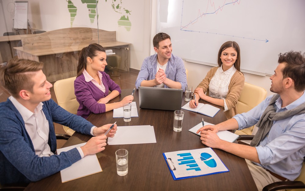 Five HR people workforce planning in an office to avoid overpayment and underpayment