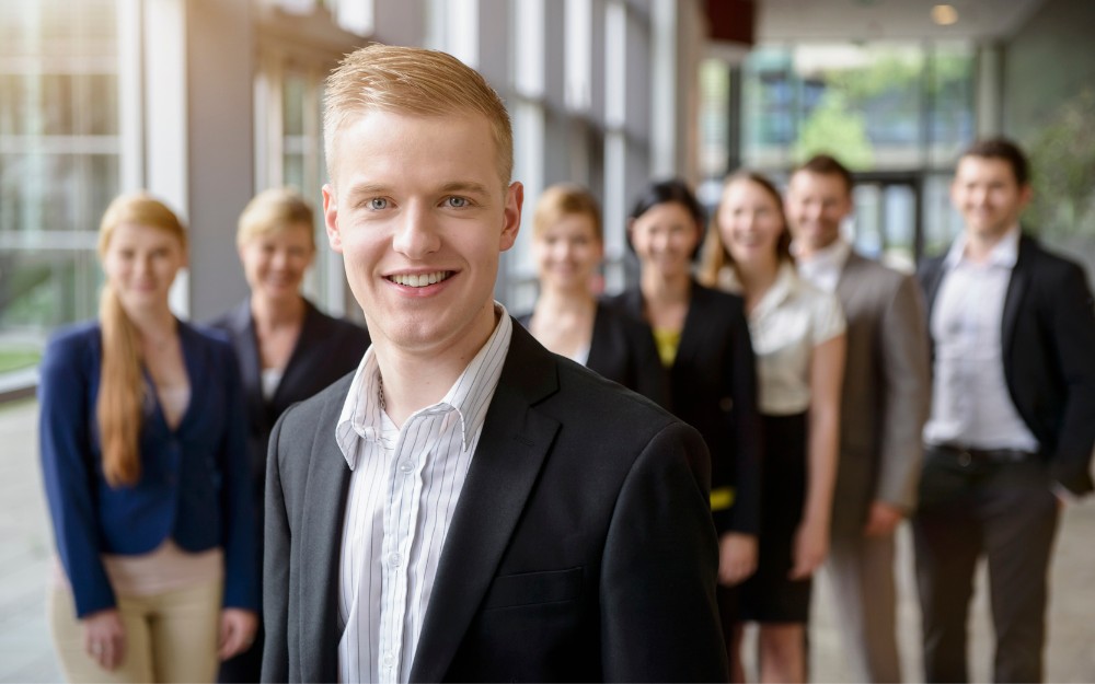Young HR professional in front of colleagues, aware of time tracking